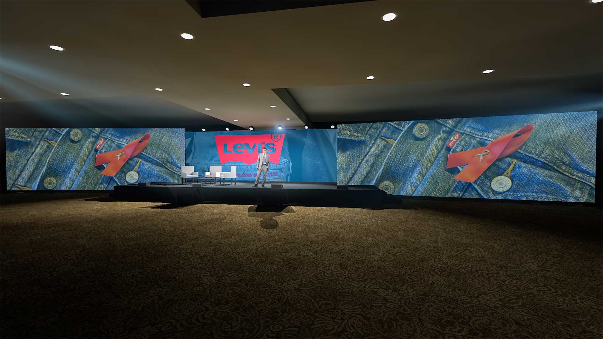 A stage setup in a ballroom featuring large screens displaying a Levi's logo and images of denim fabric. The stage has white chairs arranged for a panel discussion, and a presenter stands in front of the screens. The room is dimly lit with spotlights focusing on the stage area, creating a professional and engaging atmosphere for the event.